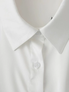 Close-up of the white shirt collar with button detail and clean fabric texture