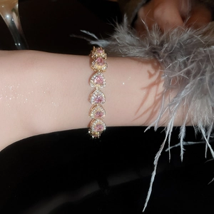 Close-up of pink heart link bracelet with gold plating and sparkling zircon stones
