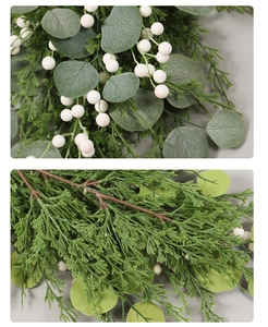 Detailed close-up of artificial eucalyptus leaves, green needles, and white berries decor