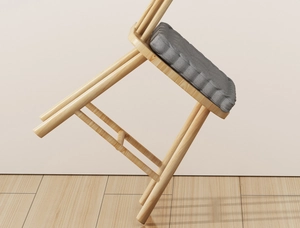 Detailed view of grey quilted cushion texture and natural wood grain on a modern stool
