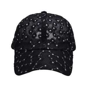 Detailed close-up of breathable black lace mesh fabric with white floral embroidery