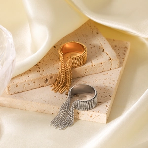 Dettaglio macro di anelli con nappe in oro e argento su un supporto in pietra