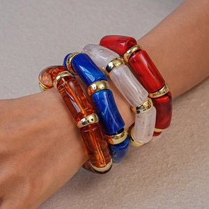 Detail of four acrylic stretch bracelets with marble textures and gold metal spacers