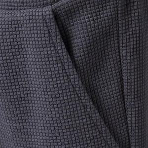 Macro view of dark grey waffle texture fabric and pocket stitching on summer sports shorts