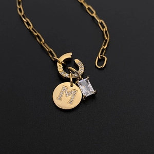 Gold stainless steel necklace featuring a sparkling letter M pendant and clear rectangular crystal
