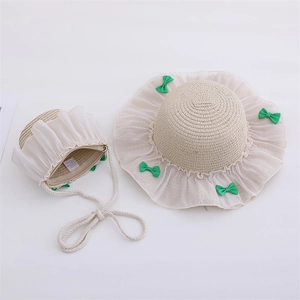 Detail of straw hat and matching purse with lace ruffles and green satin bows