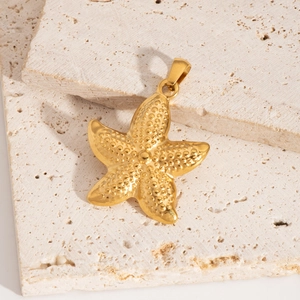 Vue détaillée d'un pendentif étoile de mer dorée avec texture sur pierre beige