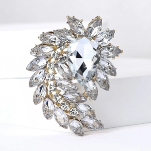 Macro shot of gold alloy brooch with crystal rhinestones on white geometric stand