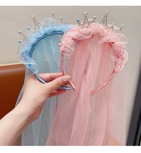 Detail of pink and blue princess crown headbands with lace veils and shiny rhinestones