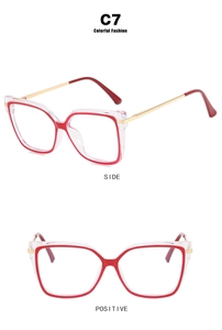 Detail view of square frame glasses with transparent red layers and gold metal temples
