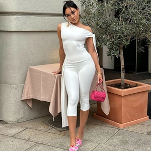 Detail of white one-shoulder slim sleeveless top and matching cropped trousers set