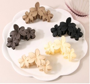 Detailed set of five matte floral hair claws in assorted colors on a cloud-shaped tray