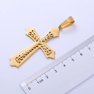 Detailed macro view of a gold double-layer cross pendant with crystal inlay and ruler for scale