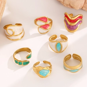 Détail de bagues émaillées colorées plaquées or avec des finitions turquoise et émeraude