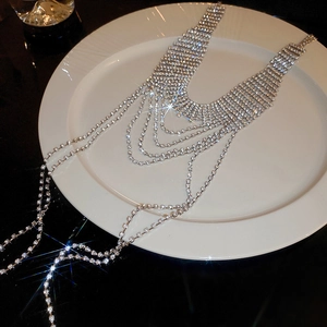 Macro di una collana multistrato con nappe di strass scintillanti su un piatto di ceramica