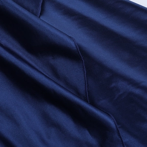 Gros plan sur le tissu en satin bleu foncé montrant une texture soyeuse et brillante