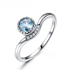 Macro shot of S925 silver curved ring featuring sky blue gemstone and accent diamonds