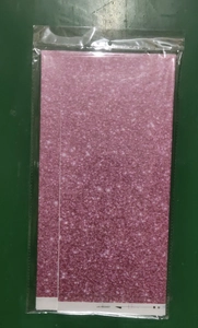Detail of pink gradient party tablecloth with glitter dots in transparent packaging