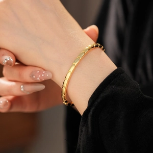 Detailed view of 18K gold plated herringbone chain bracelet with polished finish