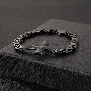Detail of a black Byzantine chain bracelet with cross pendant on a gift box