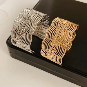 Détails des bracelets ajourés or et argent sur un écrin en cuir noir élégant