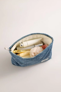 Detailed interior of blue denim cosmetic bag showing lining and storage space