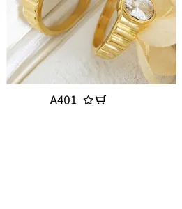 Close-up of gold plated ring with grooved texture and round clear gemstone inlay