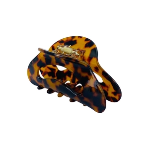 Detail view of crescent acetate hair claw clip featuring a dark tortoiseshell pattern