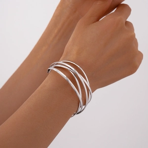 Polished silver multi-layer crossover open bangle shown on a female wrist