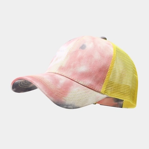 Detail of tie-dye cotton fabric and breathable yellow mesh on a trucker style baseball cap