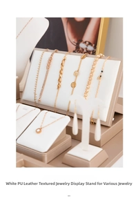 Close-up of beige PU leather jewelry display stand with fine brushed texture and gold trim