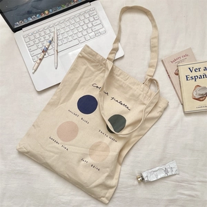 Close-up of cream canvas tote bag with color palette print and lifestyle daily essentials