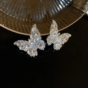 Macro detail of silver butterfly earrings encrusted with sparkling clear zircon crystals