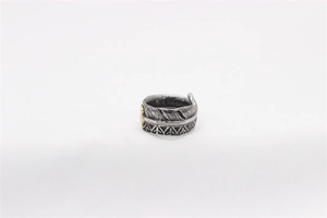 Macro detail of vintage feather titanium steel ring with intricate ethnic texture