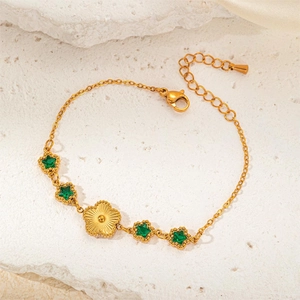 Detailed shot of gold plated bracelet featuring green star gems and sunflower charms