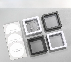 Black and white PE film floating jewelry display boxes with a silver necklace and cloth