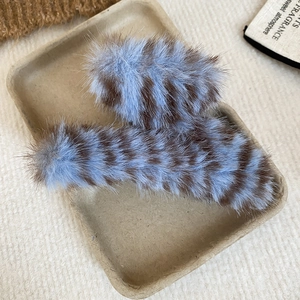 Détail macro de pinces à cheveux rayées en peluche avec une texture douce bleu et brun