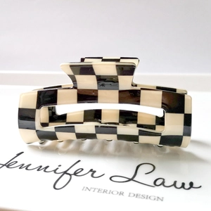 Detail view of the black and white checkerboard hair claw clip made of glossy acetate