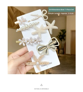 Detailed set of seven gold hair clips featuring faux pearls and sparkling rhinestones
