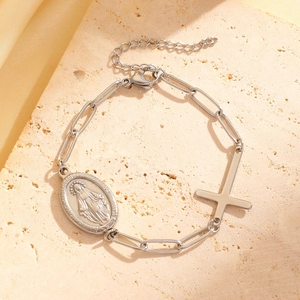Detailed macro view of silver religious bracelet with Saint Mary medal and cross pendant