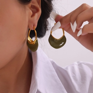 French vintage gold earrings with olive green enamel inlay shown on model in studio