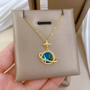 Dettaglio della collana con pendente stella dorata e pianeta blu con cristalli lucidi