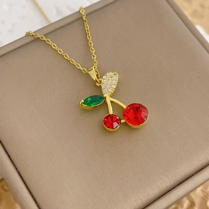 Macro shot of sparkling red cherry zircon pendant on gold chain necklace detail