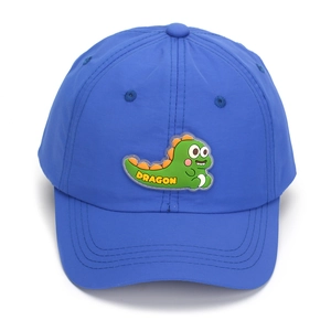 Detail of blue quick-dry kids baseball cap with green cartoon dragon silicone patch