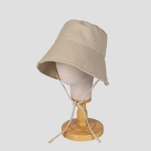 Close-up of beige wide brim sun hat with adjustable drawstring on a display stand