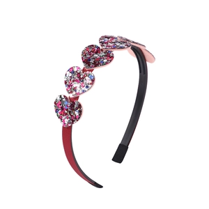 Detail showing four multi-color sequined heart charms on a black non-slip headband