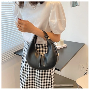 Detail of black crescent hobo bag with gold hardware and secure zipper closure