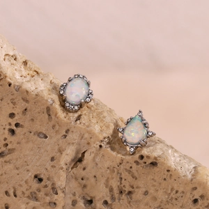 Makroaufnahme von Vintage-Opal-Ohrringen mit Kristallen auf Natursteinsockel