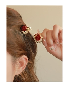 Detail of red velvet rose and rhinestone butterfly hair claw on brown hair