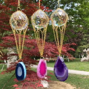 Detailed view of K9 crystal suncatchers with gold metal mesh and vibrant agate slices